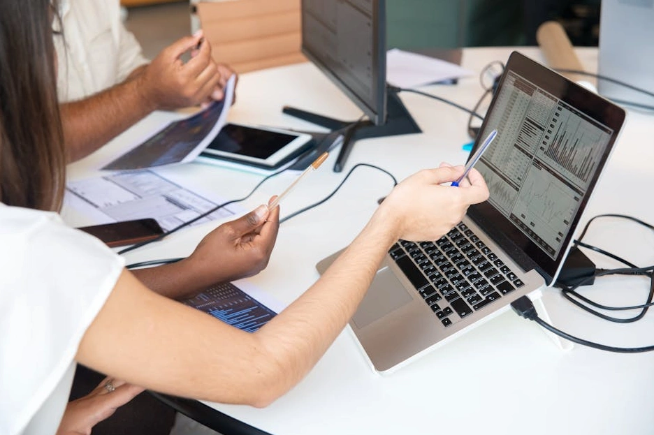 Tým konzultantů analyzuje data na moderní digitální obrazovce